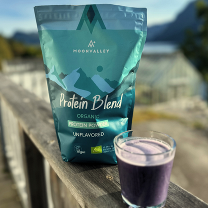 Moonvalley Organic Protein Blend 750g mountains in teh background, class full of drink