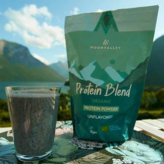 Moonvalley Organic Protein Blend 750g mountains in teh background, class full of drink